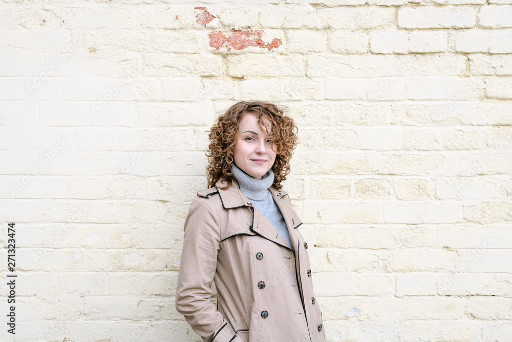Portrait of smiling woman with curly hair wearing beige trench coat Portrait of smiling woman with curly hair wearing beige trench coat