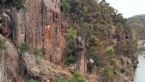 Drone shot of a climber on the red stone wall next to the Huon River in Tasmania photo