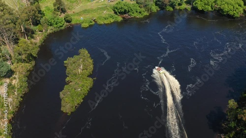 Aerial shot down looking at a speedboat which changes direction. Huon River, Tasmania. photo