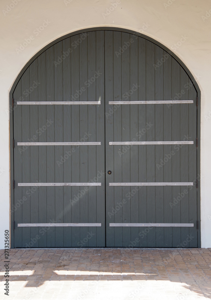 Close view of the closed arched big wooden doors of a large building gate Close view of the closed arched big wooden doors of a large building gate