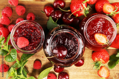 assortment of jams, seasonal berries, cherry, mint and fruits in glass jar