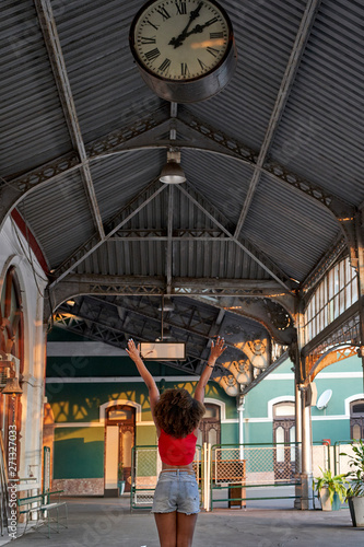 Happy woman under the clock at the train station © Westend61