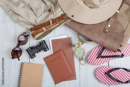 Prepare for journey in africa style - accessories and travel items, packing clothes in backpack: backpack, hat, passport, flip flops, sunglasses, compass