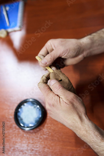 meeting potters. training courses for novice ceramists. reportage. the wizard shows how to make a penny whistle from red clay. next is a sample of a ceramic saucer with melted glass.