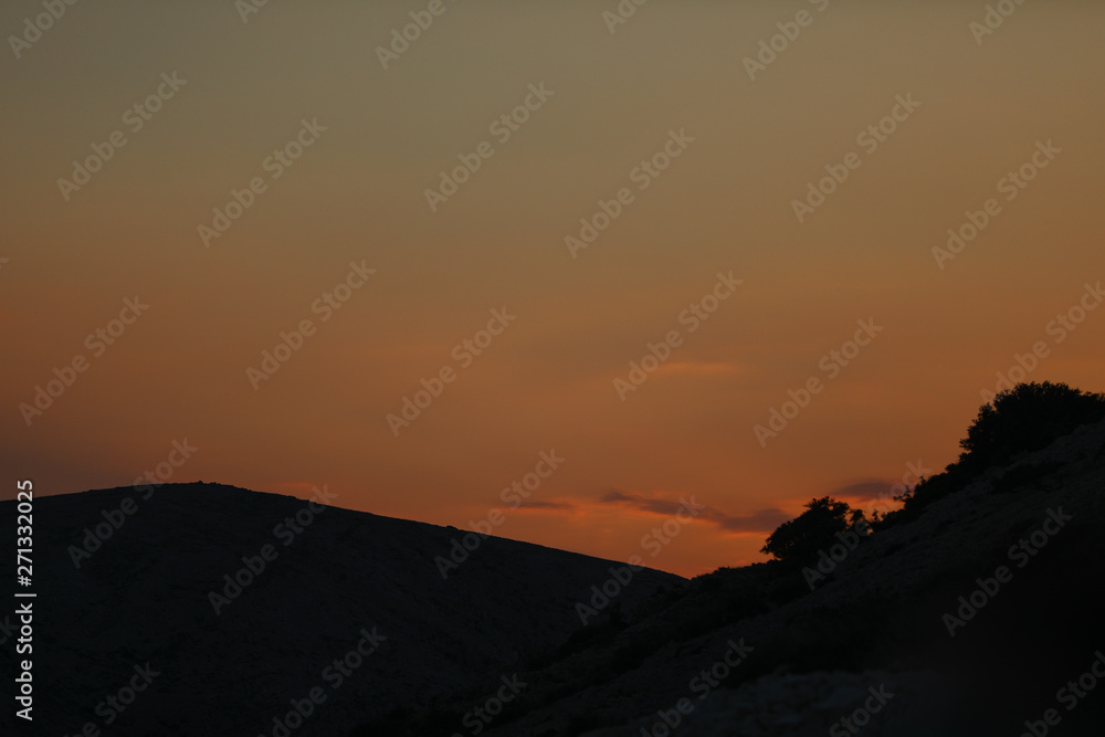 Obraz premium Matte yellow sunset in the rocks of Adriatic sea