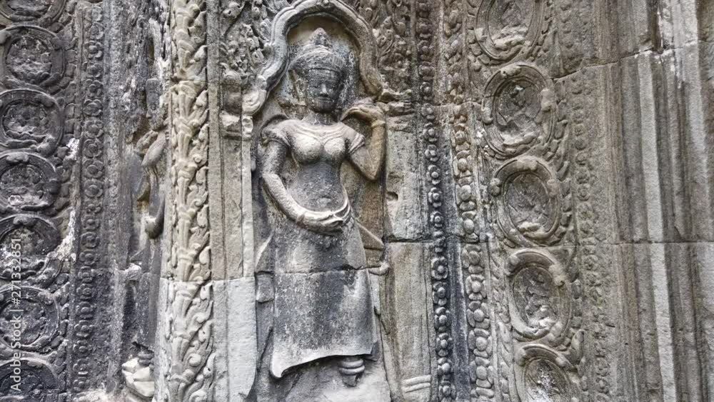 ancient bas-reliefs depicting the divine dancer Apsara in the temple of TA Prohm. One of the most famous temples of Angkor, TA Prohm is known for its huge trees and roots growing from its walls. ancient bas-reliefs depicting the divine dancer Apsara in the temple of TA Prohm. One of the most famous temples of Angkor, TA Prohm is known for its huge trees and roots growing from its walls.