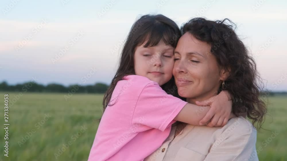 The child hugs the mother. Adorable little girl hugging her mother in summer outdoors. The child hugs the mother. Adorable little girl hugging her mother in summer outdoors.