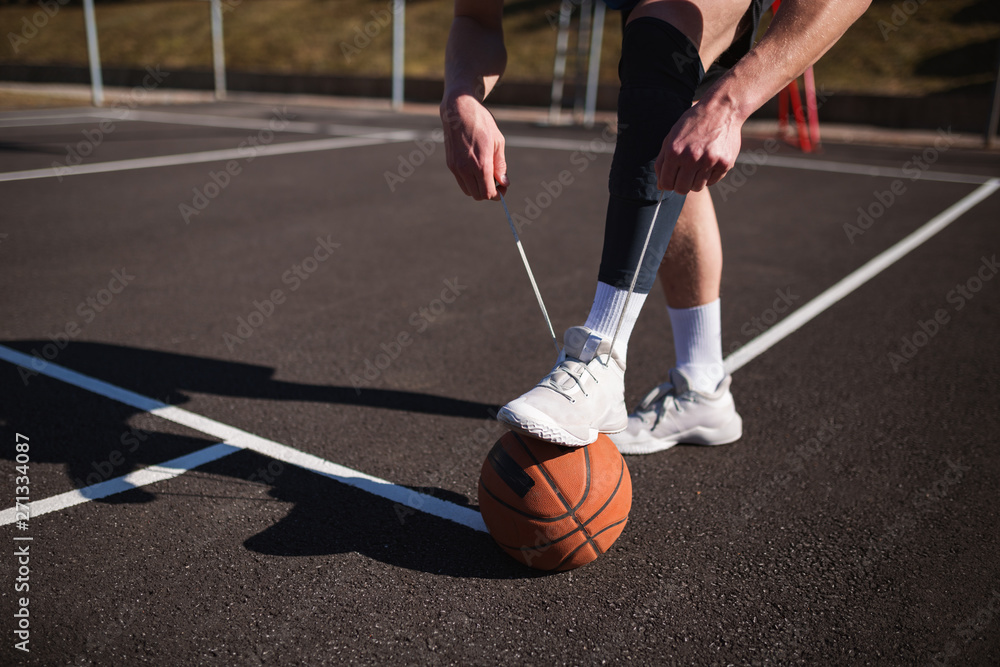 Basketball player tying basketball shoes Stock Photo Adobe Stock