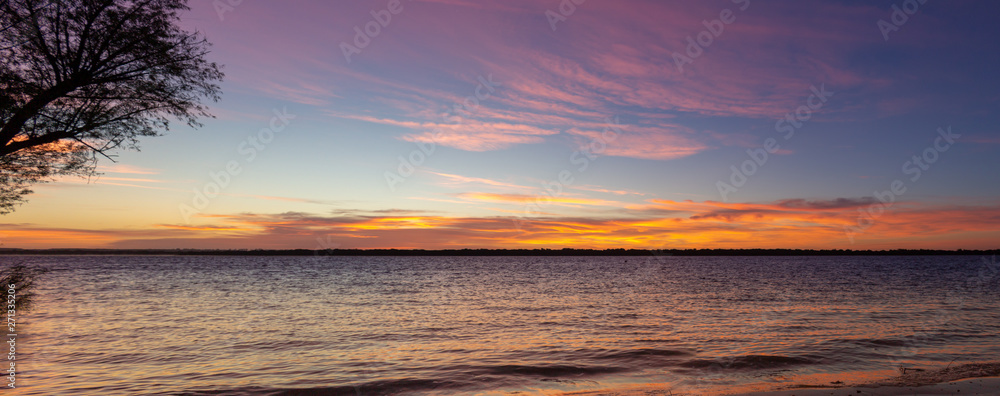 A Panoramic view of a sunset at the sea.