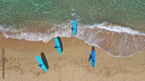 Aerial drone top view photo of young team of surfers enjoying tropical wavy turquoise sea sandy beach in exotic caribbean island