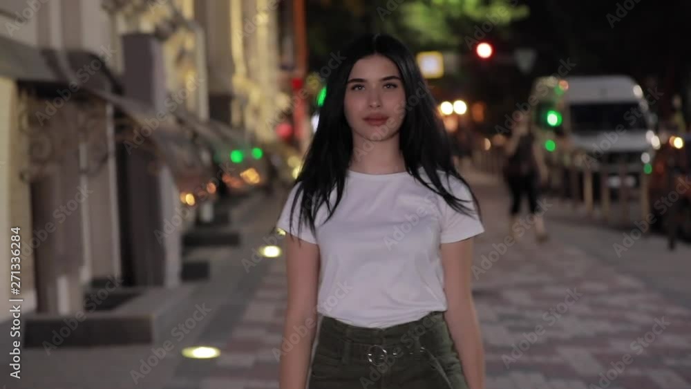 Cute woman walking in night city street Cute woman walking in night city street