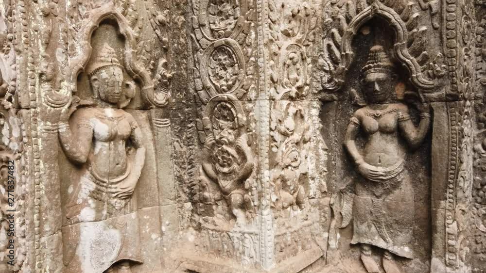 ancient bas-reliefs depicting the divine dancer Apsara in the temple of TA Prohm. One of the most famous temples of Angkor, TA Prohm is known for its huge trees and roots growing from its walls. ancient bas-reliefs depicting the divine dancer Apsara in the temple of TA Prohm. One of the most famous temples of Angkor, TA Prohm is known for its huge trees and roots growing from its walls.