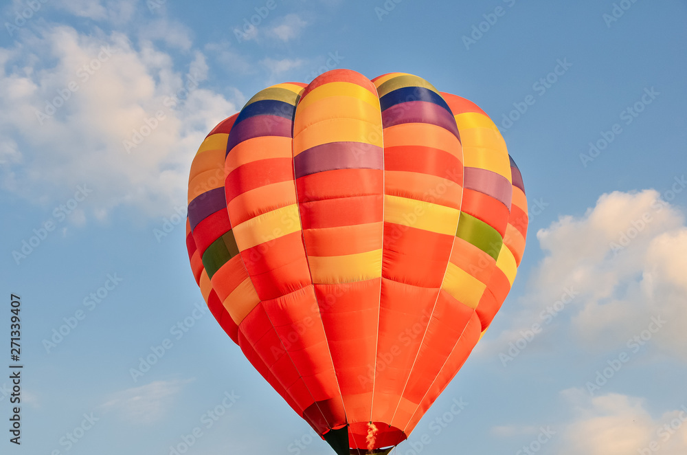 Naklejka premium Colorful hot air balloon heading up in blue sky