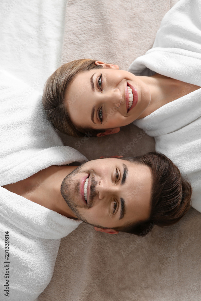 Happy young couple wearing bathrobes, top view. Visit to spa salon Happy young couple wearing bathrobes, top view. Visit to spa salon