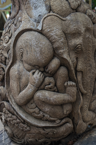Thai elephants carved on old wood at public temple
