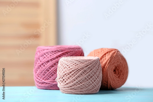 Colorful clews of threads on table against blurred background