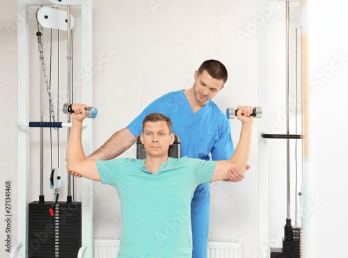 Patient exercising under physiotherapist supervision in rehabilitation center