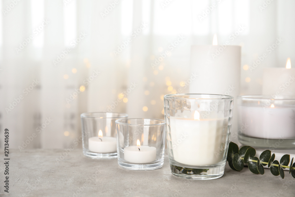 Burning aromatic candles and eucalyptus branch on table. Space for text Burning aromatic candles and eucalyptus branch on table. Space for text