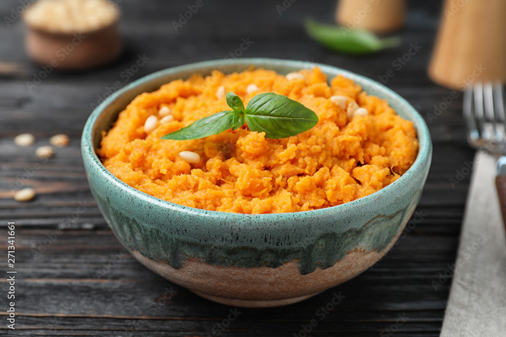 Bowl with mashed sweet potatoes on wooden table