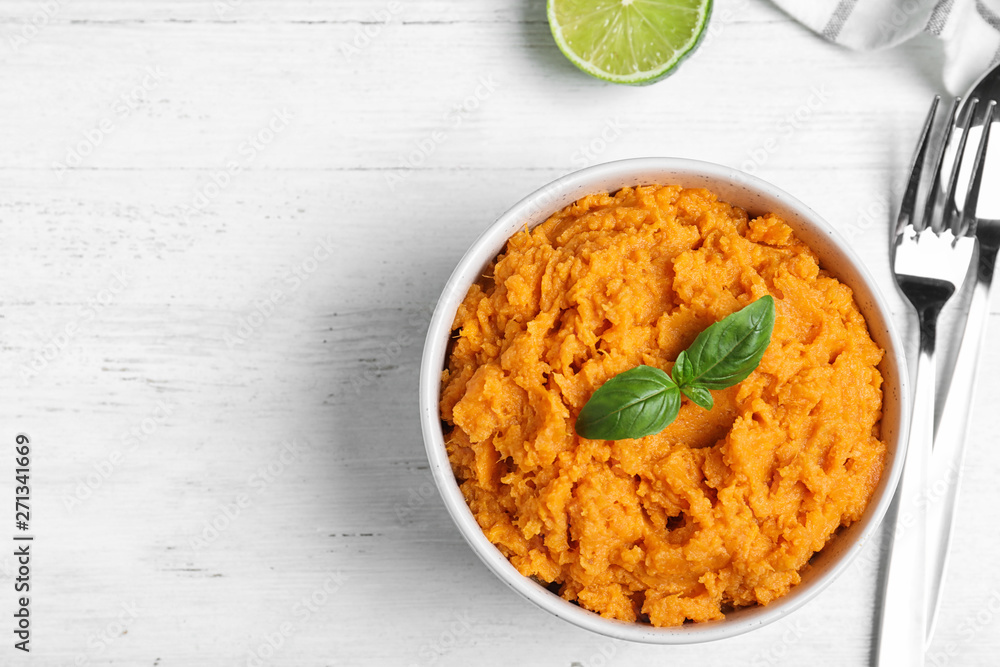 Flat lay composition with mashed sweet potatoes on wooden background, space for text Flat lay composition with mashed sweet potatoes on wooden background, space for text
