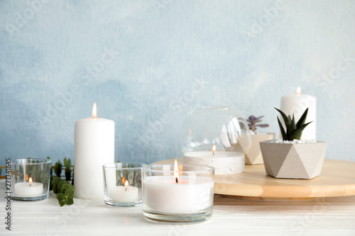Slika na platnu Burning aromatic candle and plants on table. Space for text
