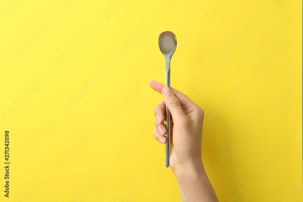 Woman holding empty soda spoon on color background, closeup. Space for text Woman holding empty soda spoon on color background, closeup. Space for text