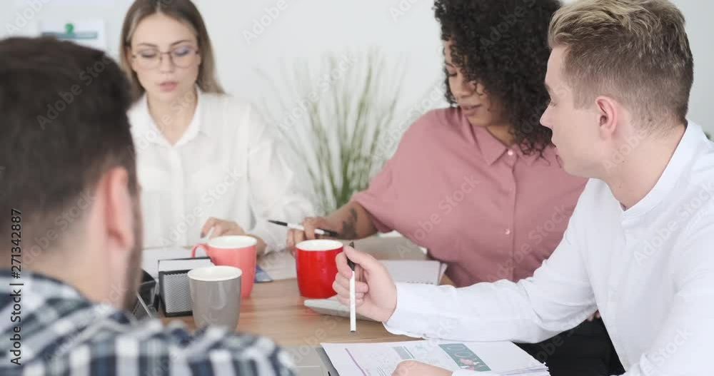 Business team discussing while calculating budget and writing notes at office meeting Business team discussing while calculating budget and writing notes at office meeting