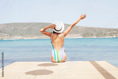  Young woman with surf board on the beach in sunny summer day