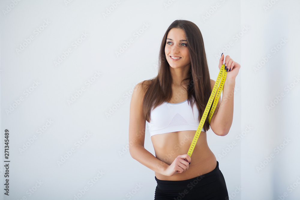 Diet. The girl taking measurements of her body, white background Diet. The girl taking measurements of her body, white background