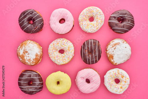 Fotografija top view of tasty glazed doughnuts on pink background