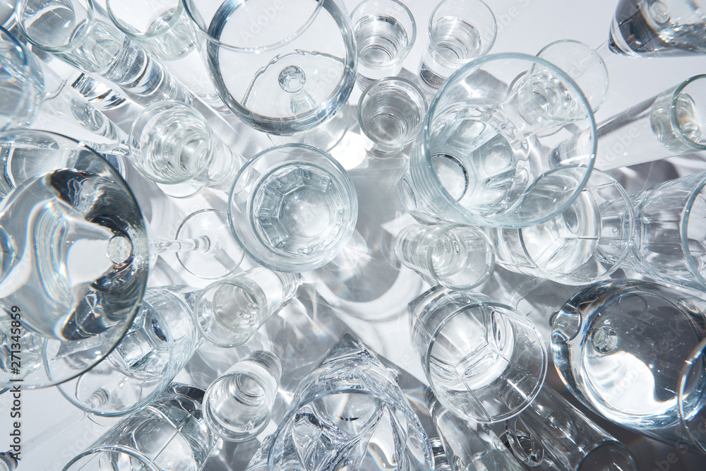 top view of transparent glasses with water on white background top view of transparent glasses with water on white background