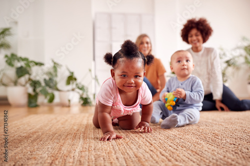 Two Mothers Meeting For Play Date With Babies At Home In Loft Apartment photo