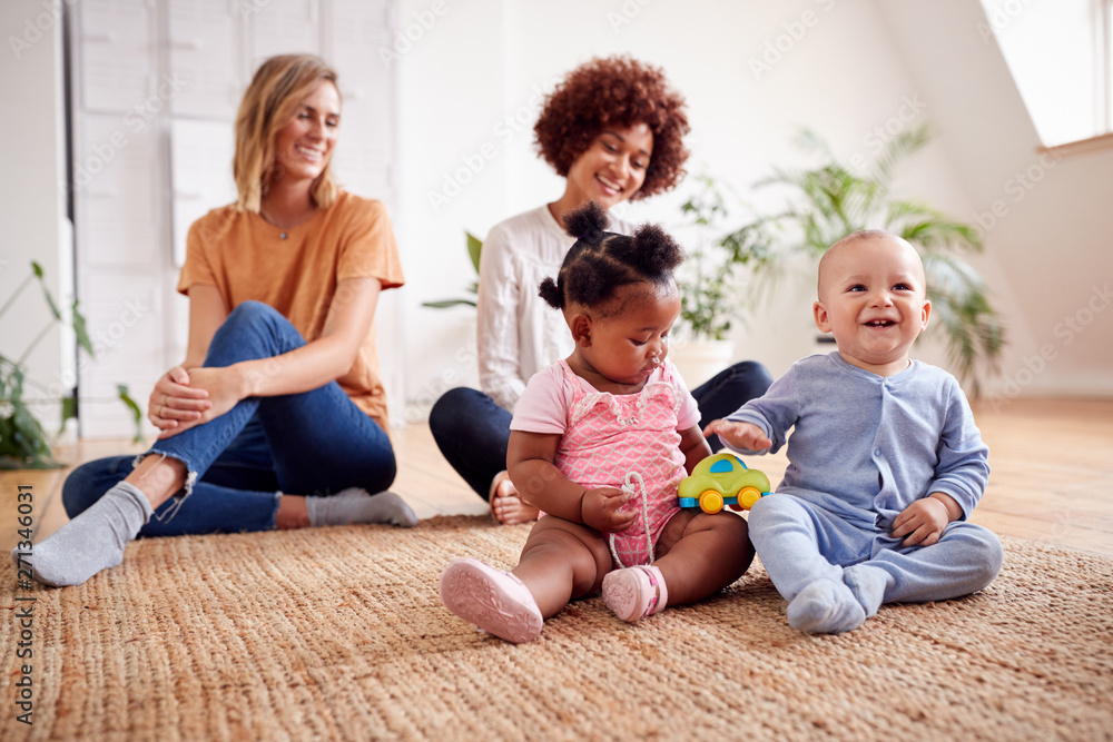 Two Mothers Meeting For Play Date With Babies At Home In Loft Apartment Two Mothers Meeting For Play Date With Babies At Home In Loft Apartment
