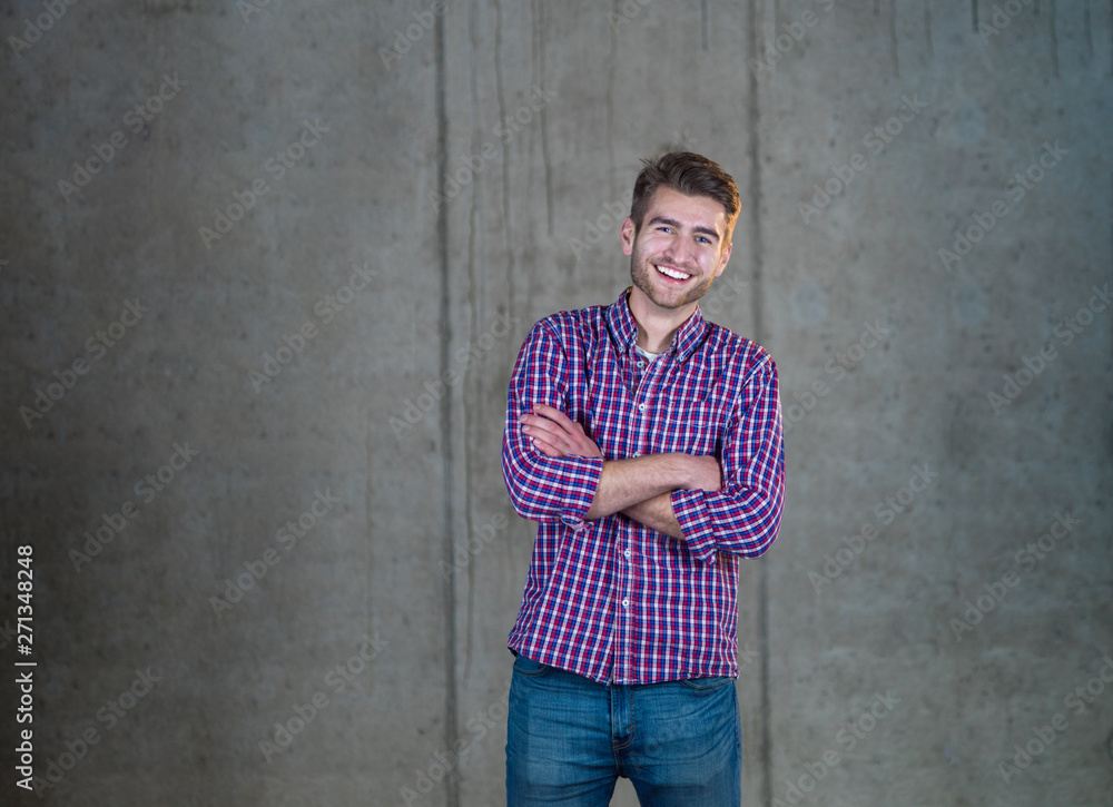 portrait of casual businessman in front of a concrete wall