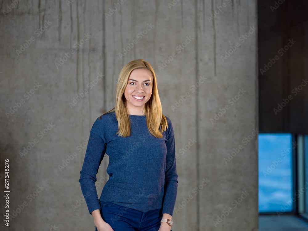 portrait of casual businesswoman in front of a concrete wall portrait of casual businesswoman in front of a concrete wall