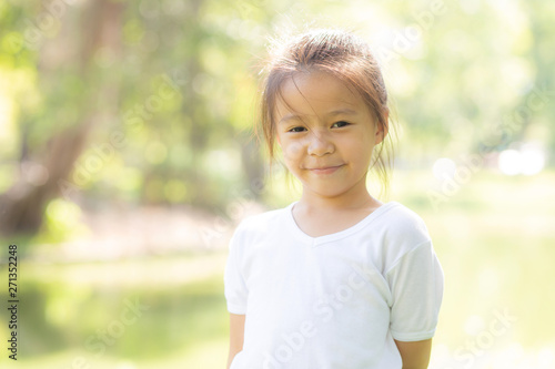 Portrait face of cute asian little girl and child happiness and fun in the park in the summer, smile and happy from asia kid and relax in the garden, lifestyle childhood concept.
