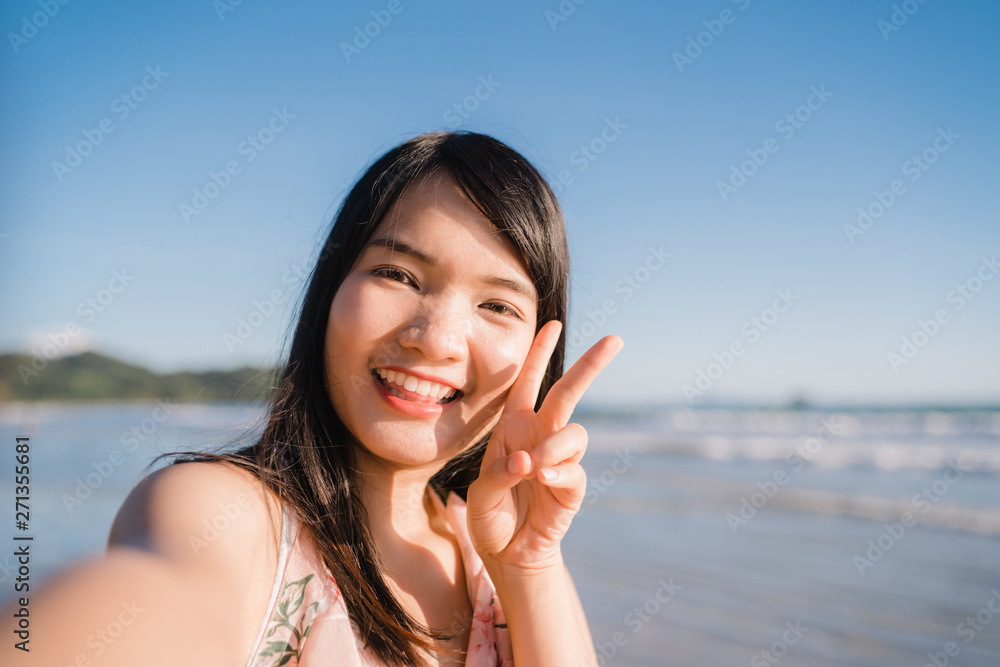 Tourist Asian woman selfie on beach, young beautiful female happy smiling using mobile phone taking selfie on beach near sea when sunset in evening. Lifestyle women travel on beach concept. Tourist Asian woman selfie on beach, young beautiful female happy smiling using mobile phone taking selfie on beach near sea when sunset in evening. Lifestyle women travel on beach concept.
