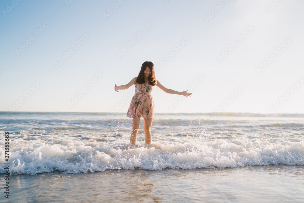 Young Asian woman walking on beach. Beautiful female happy relax walking on beach near sea when sunset in evening. Lifestyle women travel on beach concept. Young Asian woman walking on beach. Beautiful female happy relax walking on beach near sea when sunset in evening. Lifestyle women travel on beach concept.
