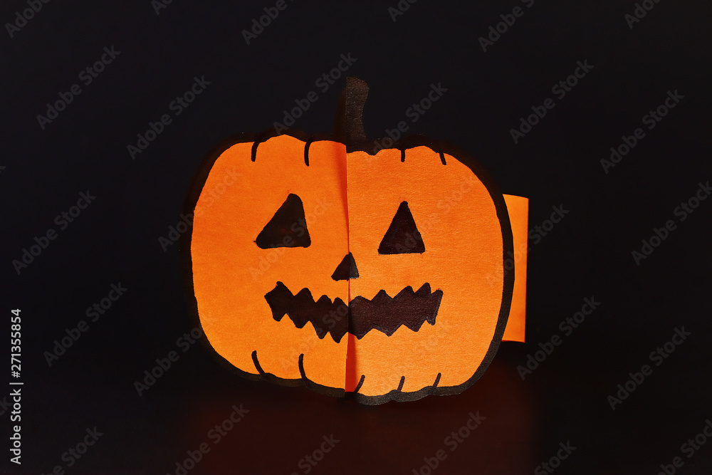 Fototapeta premium Diy Halloween paper bracelet pumpkin on black background. Gift idea, decor Halloween