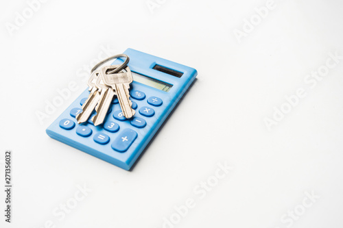 Keys on mini blue calculator isolated, home, security, bank loan, financial concept, future family planning, close up selective focus, copy space.