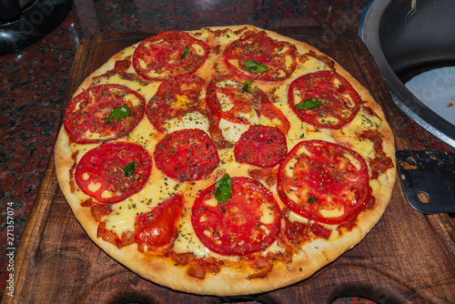 Pizza. Fresh Italian neapolitan, basil and tomato on a wooden table