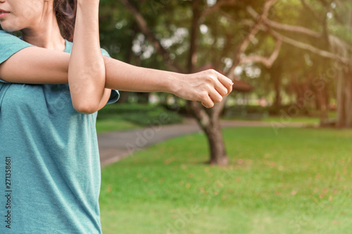 Young asian woman runner stretching arm and leg before running at morning, Exercise and health concept.