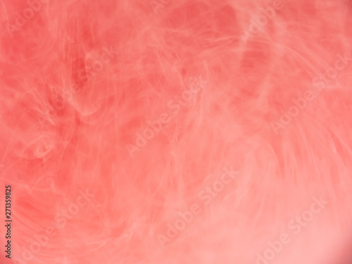 Ink dropped into liquid, abstract background. Close up view. Blurred background. Pink cloud dissolving into water, abstract pattern. Acrylic paint mixing with liquid. Abstract art