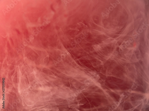 Drop of pink paint in water, abstract background. Close up view. Blurred background. Acrylic clouds swirling under water, abstract pattern. Paint mixing with liquid. Pink smoke, abstraction