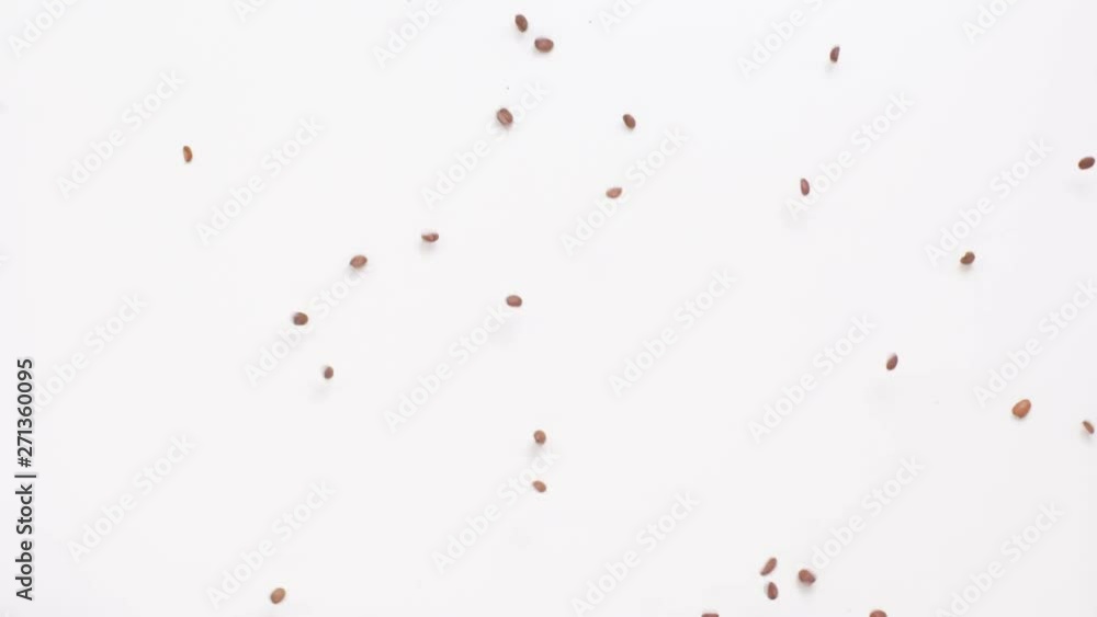 Slow motion shot looking down at coffee beans falling through the air and bouncing on the ground scattering in different directions. Slow motion shot looking down at coffee beans falling through the air and bouncing on the ground scattering in different directions.