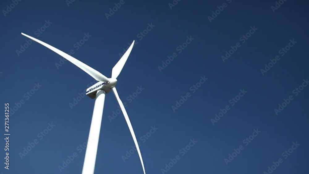 Single Wind Turbine Rotates Against Blue Sky Single Wind Turbine Rotates Against Blue Sky
