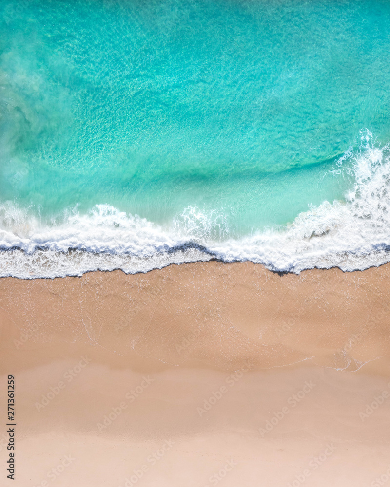 Aerial top shot of a beach with nice sand, blue turquoise water and tropical vibe