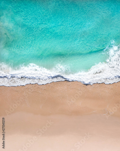 Aerial top shot of a beach with nice sand, blue turquoise water and tropical vibe