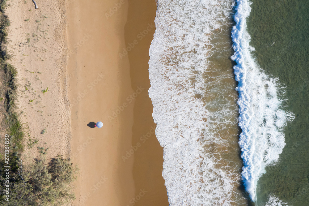 Beach aerial view of umbrellas, waves, blues ocean and relaxing vibes Beach aerial view of umbrellas, waves, blues ocean and relaxing vibes