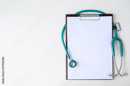 Blank medical clipboard with stethoscope on white background. photo